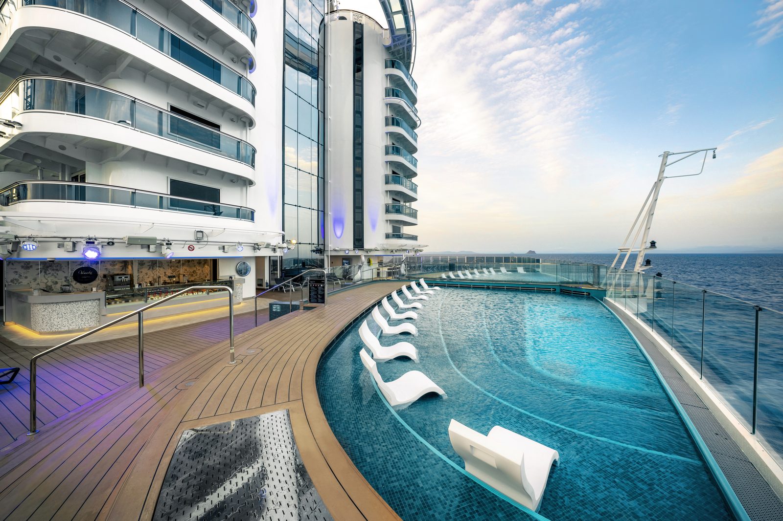 The Marina Pool deck on MSC Seascape with loungers beside a curved pool